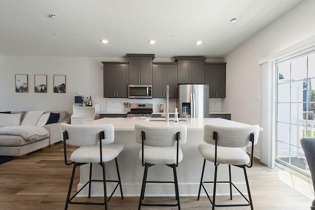 1408 Commons Ln, South Fayette, PA 15017 - kitchen with appliances with stainless steel finishes, an island with sink, a kitchen bar, light countertops, and recessed lighting