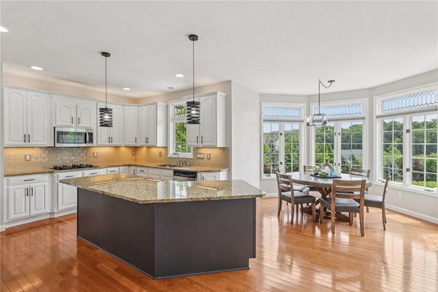 203 Cashmere Ct, Cranberry Twp, PA 16066 - kitchen featuring stainless steel microwave, black gas cooktop, white cabinetry, light stone counters, and recessed lighting