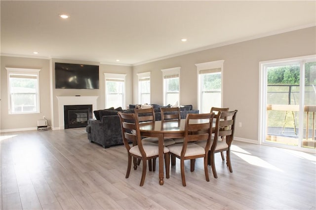 132 Hidden Acres Dr, Forward Twp, PA 16033 - dining area featuring ornamental molding, healthy amount of natural light, a glass covered fireplace, light wood-type flooring, and recessed lighting