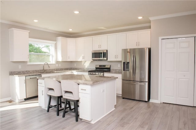 132 Hidden Acres Dr, Forward Twp, PA 16033 - kitchen featuring appliances with stainless steel finishes, a center island, white cabinetry, light stone countertops, and light wood-style floors