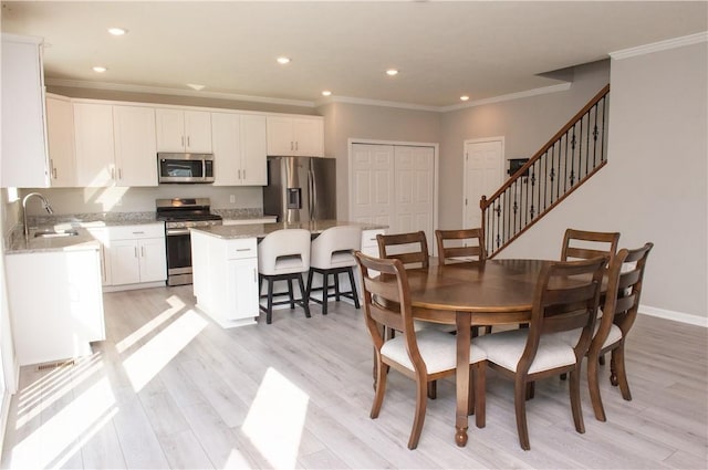 132 Hidden Acres Dr, Forward Twp, PA 16033 - dining space with ornamental molding, light wood finished floors, stairway, and recessed lighting
