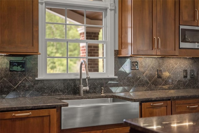 116 Bunker Hill Dr, Peters Twp, PA 15317 - kitchen featuring stainless steel microwave, plenty of natural light, brown cabinetry, and tasteful backsplash
