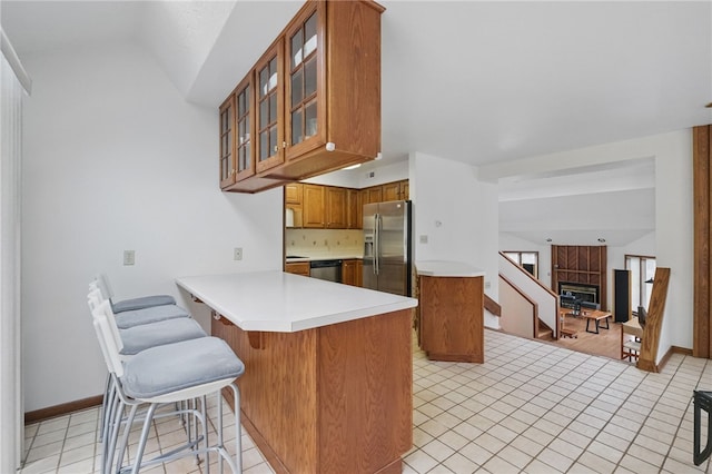 1 Quail Hill Rd, Fox Chapel, PA 15238 - kitchen with stainless steel appliances, brown cabinetry, a peninsula, glass insert cabinets, and light countertops