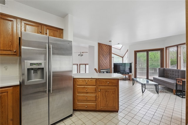1 Quail Hill Rd, Fox Chapel, PA 15238 - kitchen with stainless steel fridge with ice dispenser, brown cabinetry, a skylight, and light tile patterned flooring