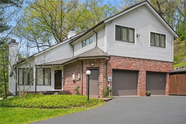 1 Quail Hill Rd, Fox Chapel, PA 15238 - view of front of house featuring a chimney, a garage, brick siding, and asphalt driveway
