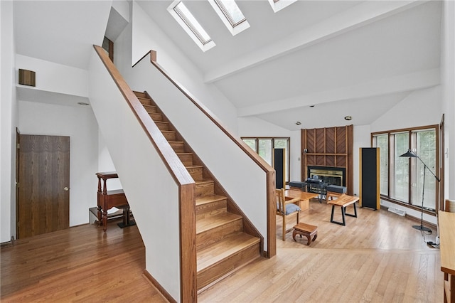 1 Quail Hill Rd, Fox Chapel, PA 15238 - stairway with wood finished floors, a skylight, a tiled fireplace, high vaulted ceiling, and beamed ceiling