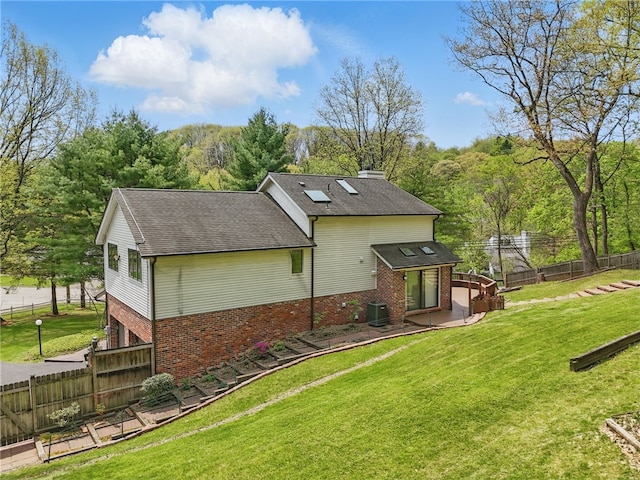 1 Quail Hill Rd, Fox Chapel, PA 15238 - back of house featuring brick siding, a chimney, a fenced backyard, a shingled roof, and a patio