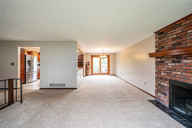 317 Bridlewood Dr, Hempfield Twp Wml, PA 15601 - unfurnished living room with a brick fireplace, a chandelier, and light carpet