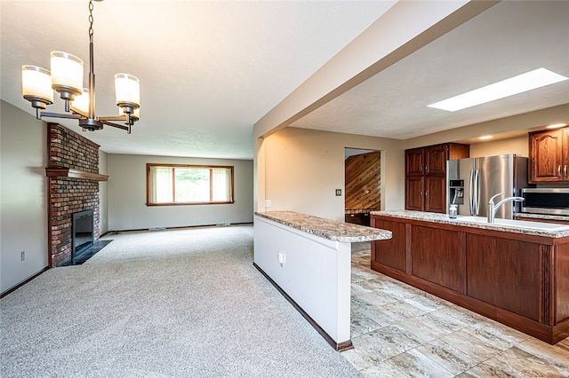 317 Bridlewood Dr, Hempfield Twp Wml, PA 15601 - kitchen featuring stainless steel appliances, open floor plan, a chandelier, a fireplace, and hanging light fixtures