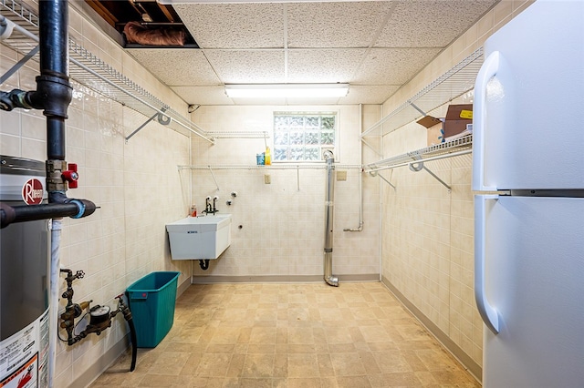 317 Bridlewood Dr, Hempfield Twp Wml, PA 15601 - below grade area with freestanding refrigerator, tile walls, and a drop ceiling