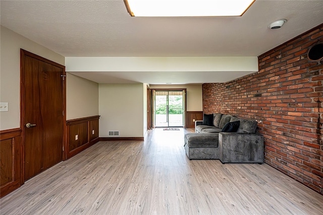 317 Bridlewood Dr, Hempfield Twp Wml, PA 15601 - living room featuring brick wall, light wood finished floors, and a wainscoted wall