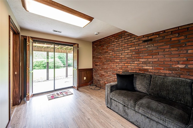 317 Bridlewood Dr, Hempfield Twp Wml, PA 15601 - living room with light wood-style flooring, wainscoting, and brick wall