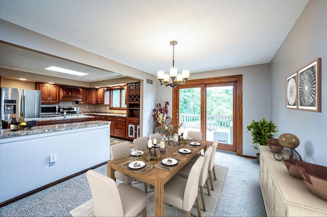 317 Bridlewood Dr, Hempfield Twp Wml, PA 15601 - dining room with light carpet, a chandelier, and a textured ceiling