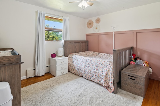 1343 Venetia Rd, Nottingham, PA 15330 - bedroom with wood finished floors, a decorative wall, wainscoting, a baseboard heating unit, and ceiling fan