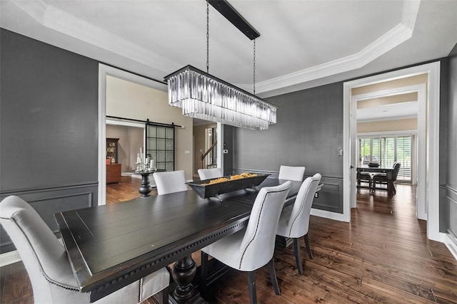 306 Hedgerow Dr, Peters Twp, PA 15367 - dining space featuring a barn door, crown molding, dark wood-type flooring, and a tray ceiling