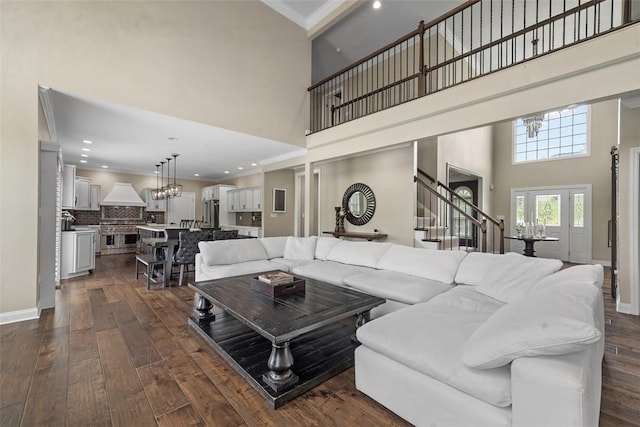 306 Hedgerow Dr, Peters Twp, PA 15367 - living room featuring a towering ceiling, dark wood-style flooring, stairway, a chandelier, and ornamental molding