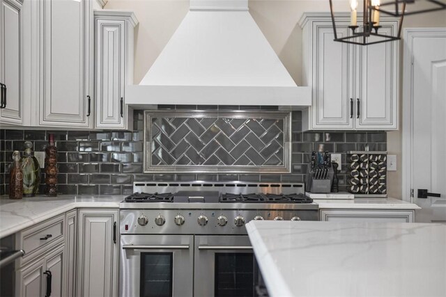306 Hedgerow Dr, Peters Twp, PA 15367 - kitchen featuring premium range hood, double oven range, backsplash, light stone counters, and a chandelier