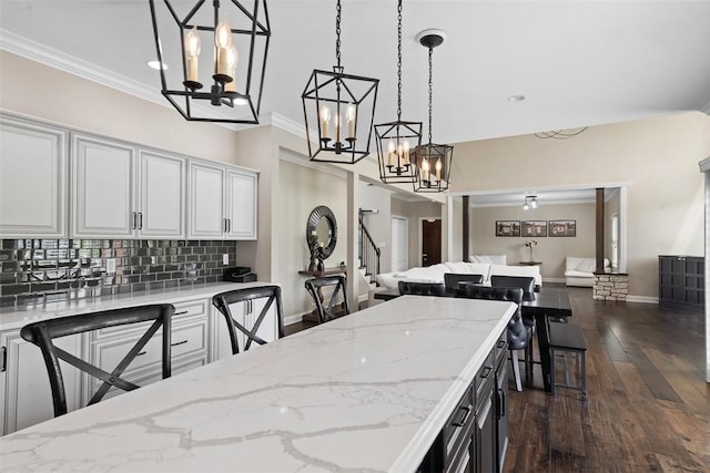 306 Hedgerow Dr, Peters Twp, PA 15367 - kitchen with a chandelier, tasteful backsplash, decorative light fixtures, dark wood-style flooring, and light stone counters
