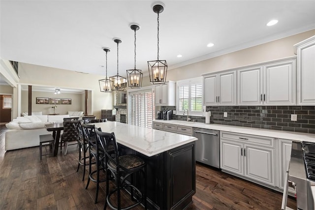 306 Hedgerow Dr, Peters Twp, PA 15367 - kitchen with stainless steel dishwasher, range, tasteful backsplash, dark wood-type flooring, and a kitchen bar