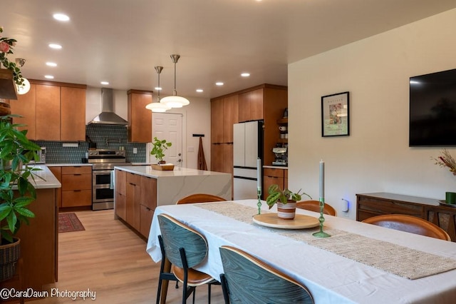 8 Windycrest Dr, Patterson Twp, PA 15010 - kitchen featuring wall chimney exhaust hood, electric range, light wood-type flooring, freestanding refrigerator, and a center island