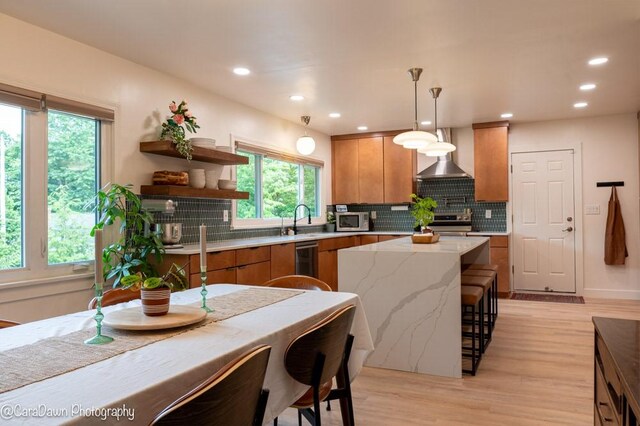 8 Windycrest Dr, Patterson Twp, PA 15010 - kitchen featuring wall chimney range hood, brown cabinetry, appliances with stainless steel finishes, light wood-style flooring, and recessed lighting