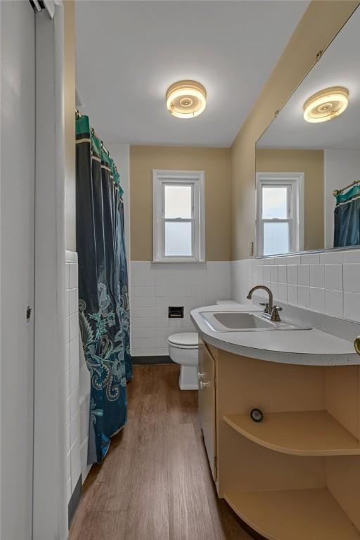 1558 Jackson St, Aliquippa, PA 15001 - bathroom with tile walls, vanity, plenty of natural light, wainscoting, and wood finished floors