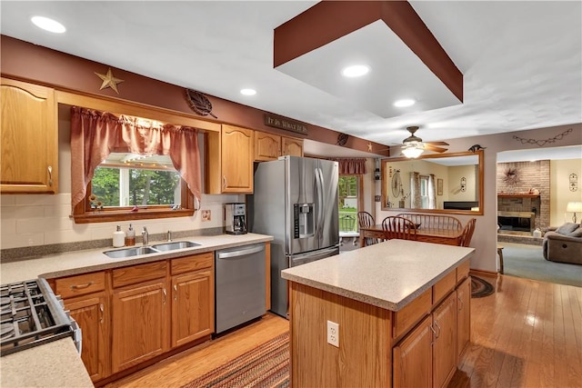 108 Birchwood Way, Penn Twp Wml, PA 15642 - kitchen with stainless steel appliances, a ceiling fan, light countertops, a fireplace, and light wood-type flooring