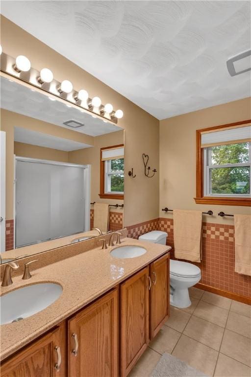 108 Birchwood Way, Penn Twp Wml, PA 15642 - bathroom with tile walls, tile patterned floors, double vanity, wainscoting, and a shower with door