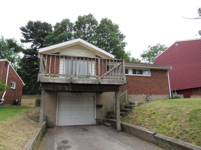 129 Windsor Dr, Penn Hills, PA 15235 - view of front of property with brick siding, a garage, driveway, and a front yard