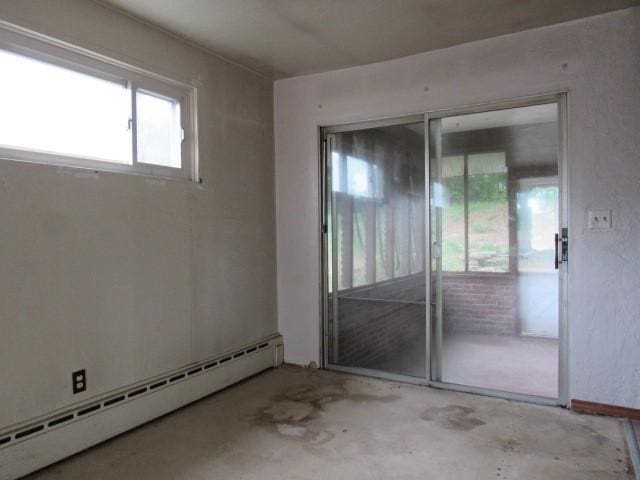 129 Windsor Dr, Penn Hills, PA 15235 - empty room featuring a baseboard heating unit and unfinished concrete flooring