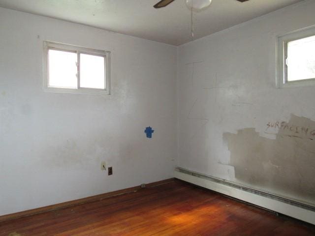 129 Windsor Dr, Penn Hills, PA 15235 - unfurnished room with a baseboard heating unit, ceiling fan, and wood finished floors