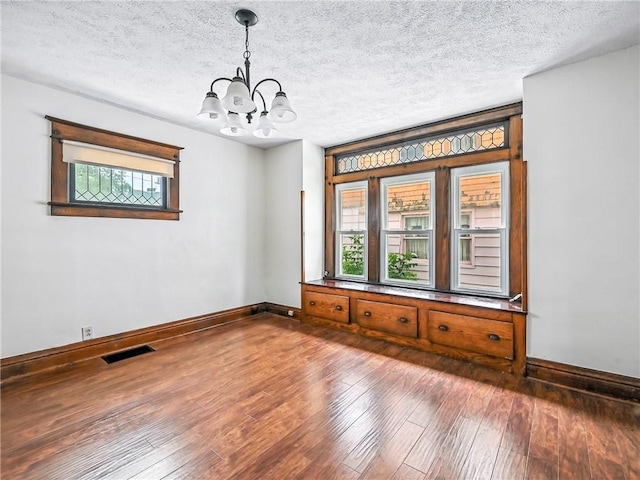 385 Spruce Ave, Sharon, PA 16146 - spare room with a chandelier, plenty of natural light, hardwood / wood-style floors, and a textured ceiling