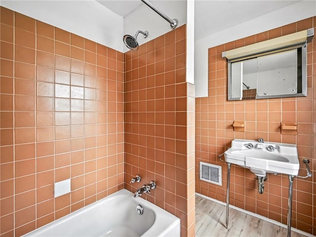 385 Spruce Ave, Sharon, PA 16146 - bathroom featuring tile walls, wood finished floors, and shower / bath combination
