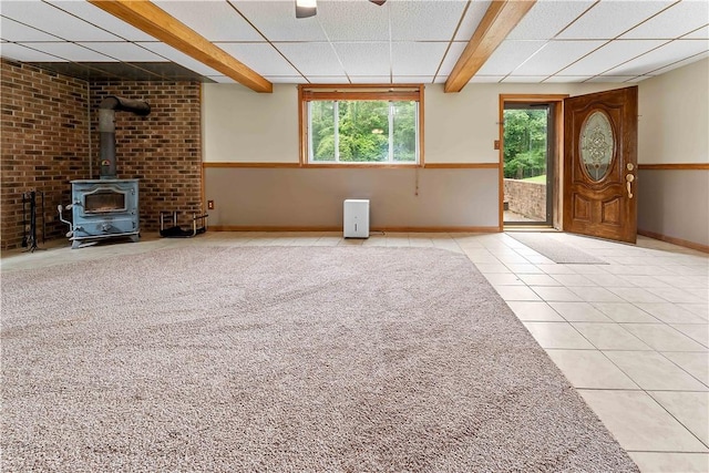 2228 Dinnerbell Five Forks Rd, Wharton Twp, PA 15437 - unfurnished living room featuring tile patterned flooring, a wood stove, healthy amount of natural light, beamed ceiling, and a drop ceiling