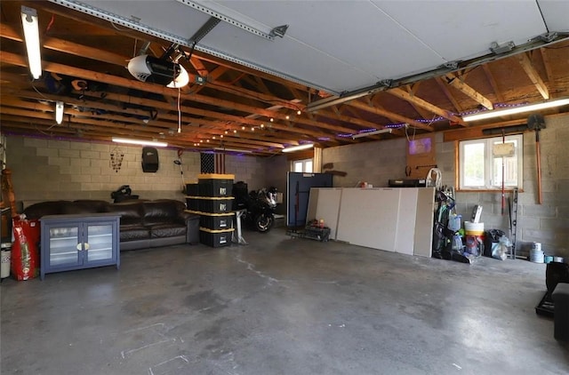 407 1st St, South Union Twp, PA 15401 - garage featuring a garage door opener, concrete block wall, and fridge