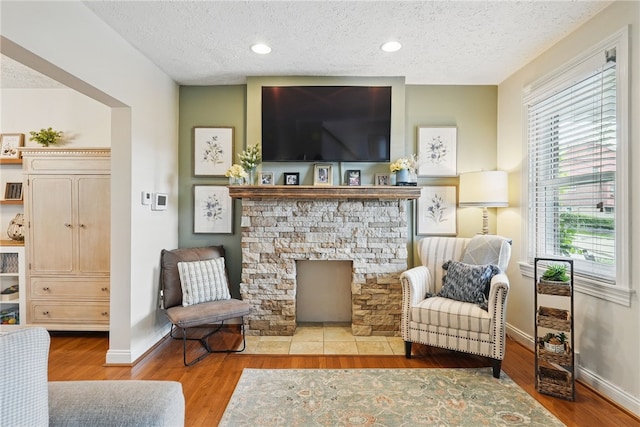 3236 Beacon Hill Ave, Dormont, PA 15216 - living area featuring a textured ceiling, wood finished floors, a fireplace, and recessed lighting