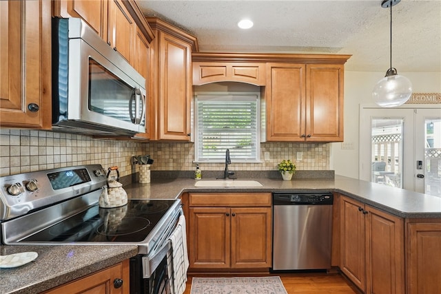 3236 Beacon Hill Ave, Dormont, PA 15216 - kitchen with appliances with stainless steel finishes, dark countertops, brown cabinetry, a peninsula, and a textured ceiling