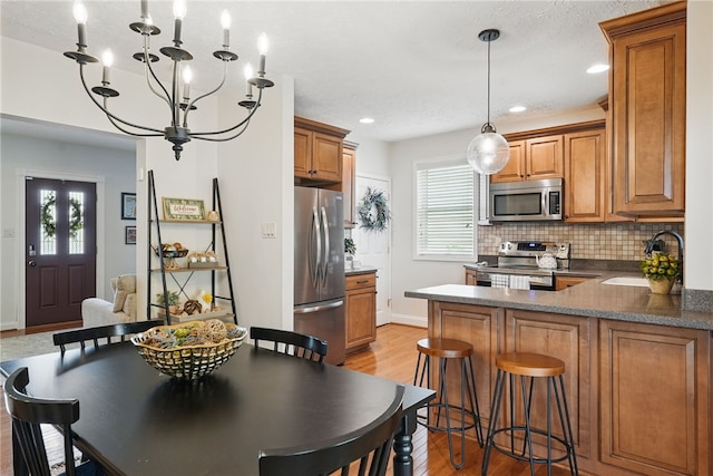 3236 Beacon Hill Ave, Dormont, PA 15216 - kitchen featuring stainless steel appliances, brown cabinetry, a peninsula, light wood finished floors, and recessed lighting