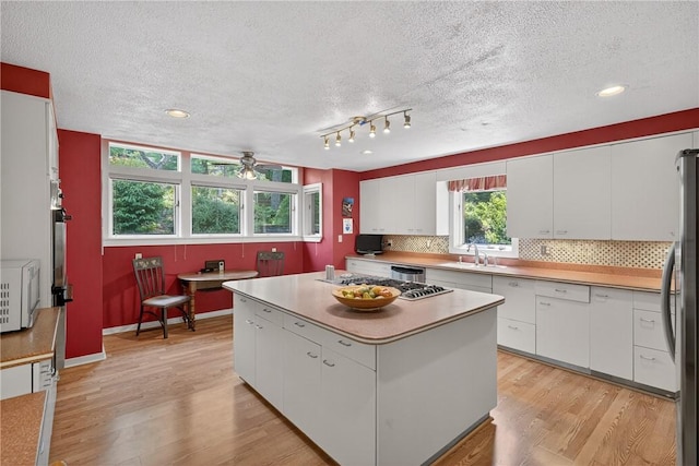 117 Scarborough Ln, Peters Twp, PA 15317 - kitchen with white cabinetry, ceiling fan, light wood-type flooring, decorative backsplash, and a textured ceiling