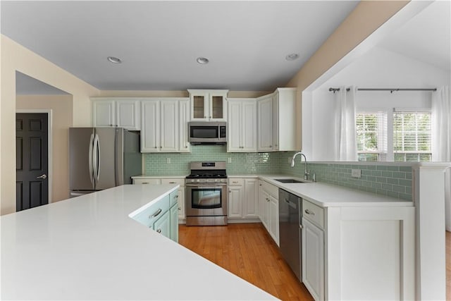 4015 Bentwood Dr, North Strabane, PA 15317 - kitchen featuring appliances with stainless steel finishes, light countertops, decorative backsplash, white cabinets, and light wood finished floors