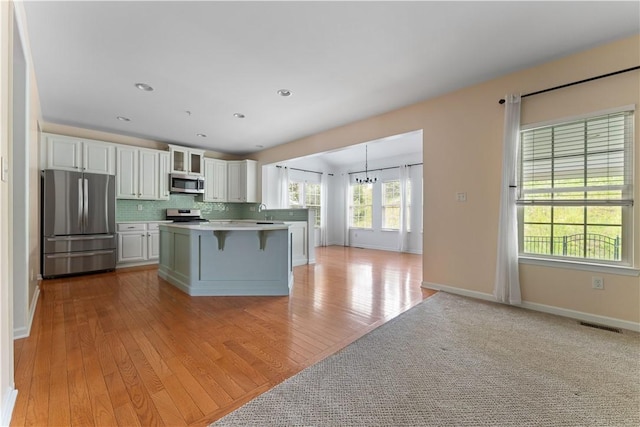 4015 Bentwood Dr, North Strabane, PA 15317 - kitchen featuring appliances with stainless steel finishes, white cabinetry, a kitchen bar, backsplash, and light countertops