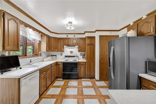 12169 Pine Crest Ct, North Huntingdon, PA 15085 - kitchen featuring stainless steel appliances, under cabinet range hood, brown cabinetry, decorative backsplash, and crown molding