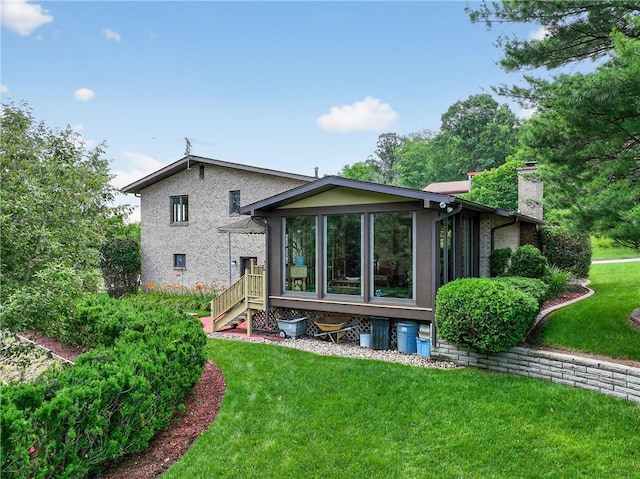 12169 Pine Crest Ct, North Huntingdon, PA 15085 - rear view of house featuring a yard, a chimney, a sunroom, and brick siding