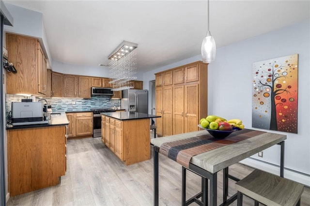 537 Center Church Rd, Peters Twp, PA 15317 - kitchen with stainless steel appliances, light wood finished floors, decorative backsplash, a center island, and dark countertops