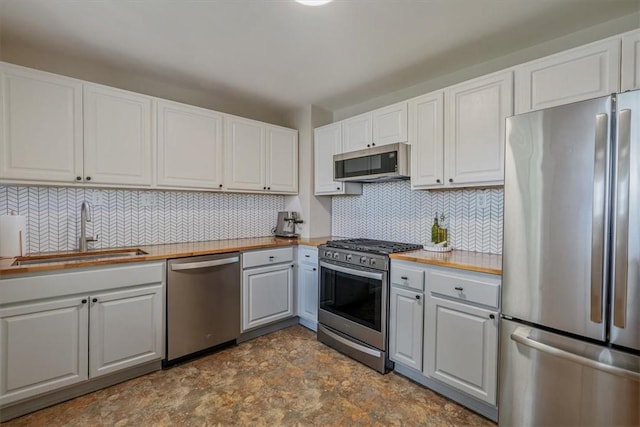 2125 Vodeli St, Beechview, PA 15216 - kitchen with appliances with stainless steel finishes, stone finish floors, gray cabinetry, tasteful backsplash, and white cabinets