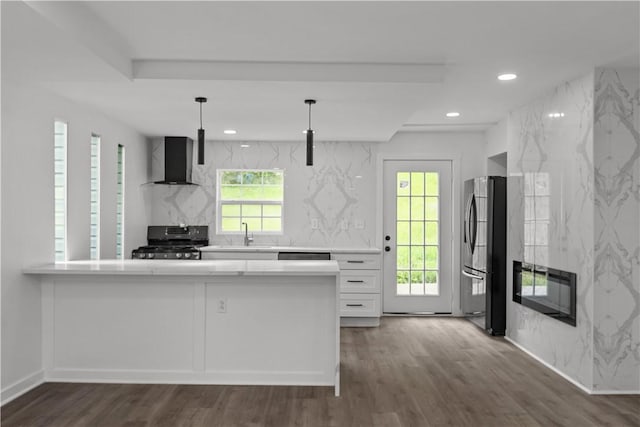 2513 Grove Rd, South Park, PA 15129 - kitchen with gas stove, wall chimney range hood, freestanding refrigerator, light countertops, and white cabinets