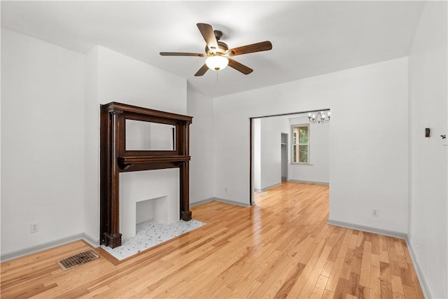 841 Stanton Ave, Millvale, PA 15209 - unfurnished living room featuring ceiling fan, light wood finished floors, and a chandelier