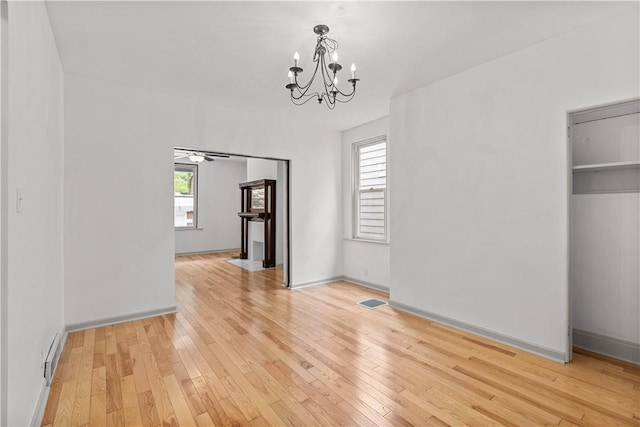 841 Stanton Ave, Millvale, PA 15209 - unfurnished dining area featuring a chandelier, light wood-type flooring, and healthy amount of natural light