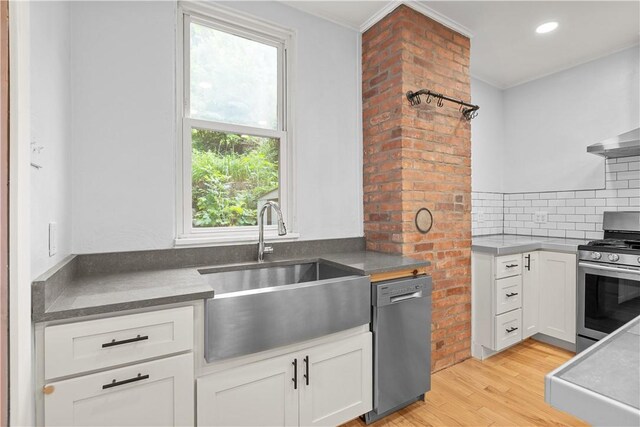841 Stanton Ave, Millvale, PA 15209 - kitchen featuring appliances with stainless steel finishes, light wood-type flooring, backsplash, white cabinetry, and crown molding