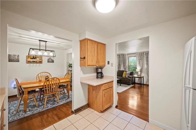 524 Sandy Hill Rd, Manor, PA 15642 - kitchen featuring freestanding refrigerator, light countertops, light wood-type flooring, and hanging light fixtures